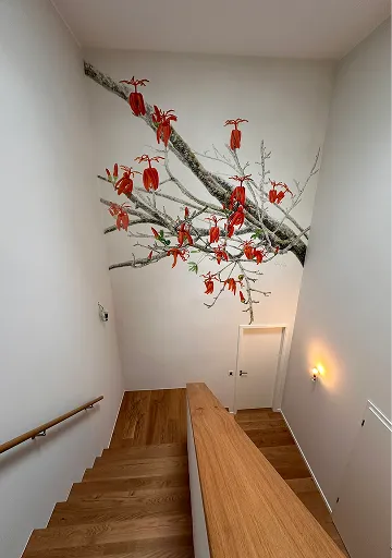 Treppenhaus mit Wandmotiv eines blühenden Astes