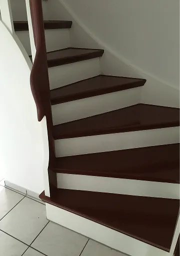 Gewendelte Treppe mit dunkelbraun lackierten Stufen
