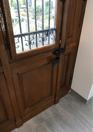 Aufgearbeitete Holzhaustür mit Ziergitter